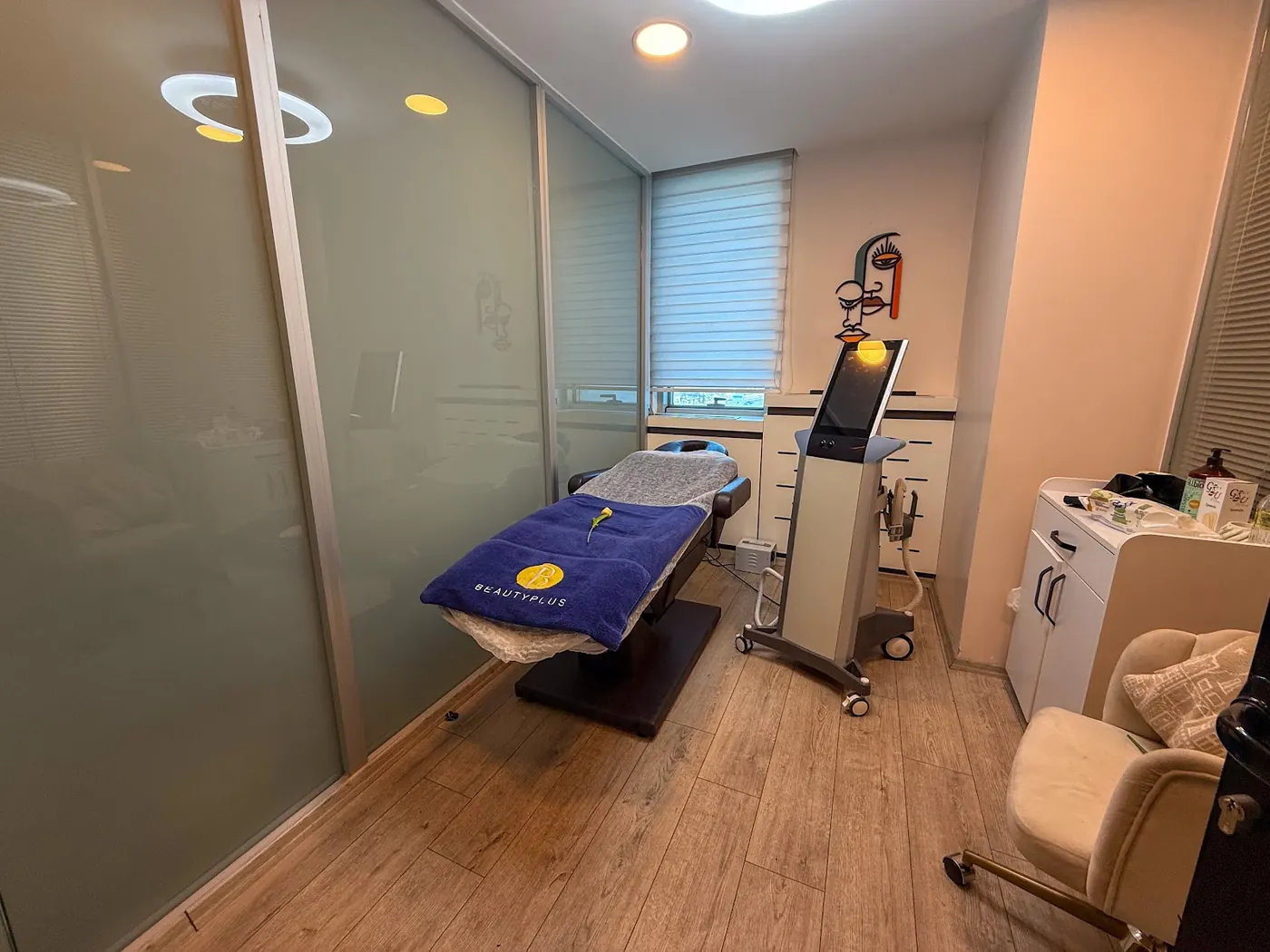 BeautyPlus Kozyatağı'nda yüz illüstrasyonlu duvarı ve uygulama yatağıyla aydınlık uygulama odası
