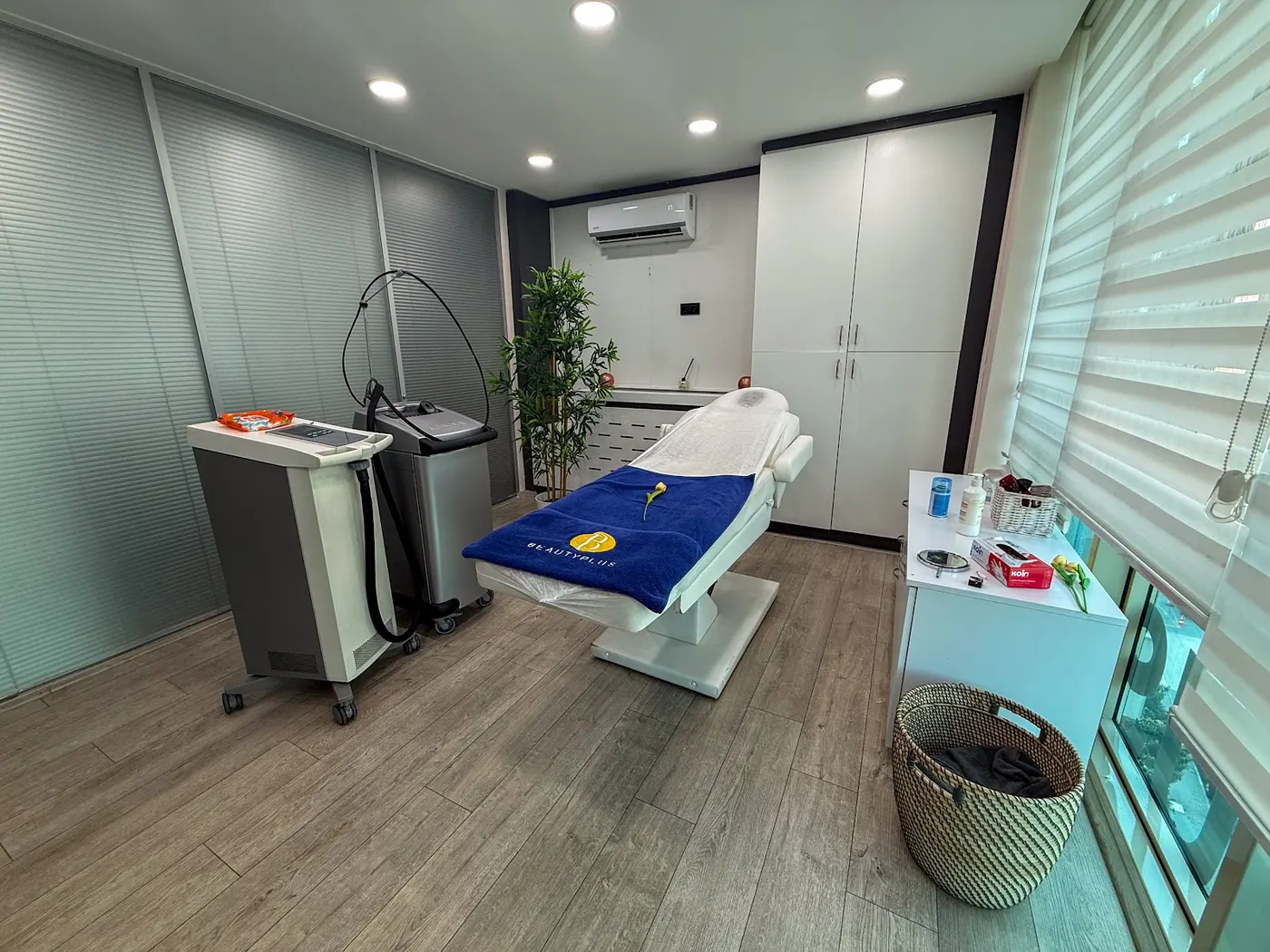 BeautyPlus Kozyatağı'nda iki cihaz ve mavi BeautyPlus havlulu yatak bulunan geniş uygulama odası
